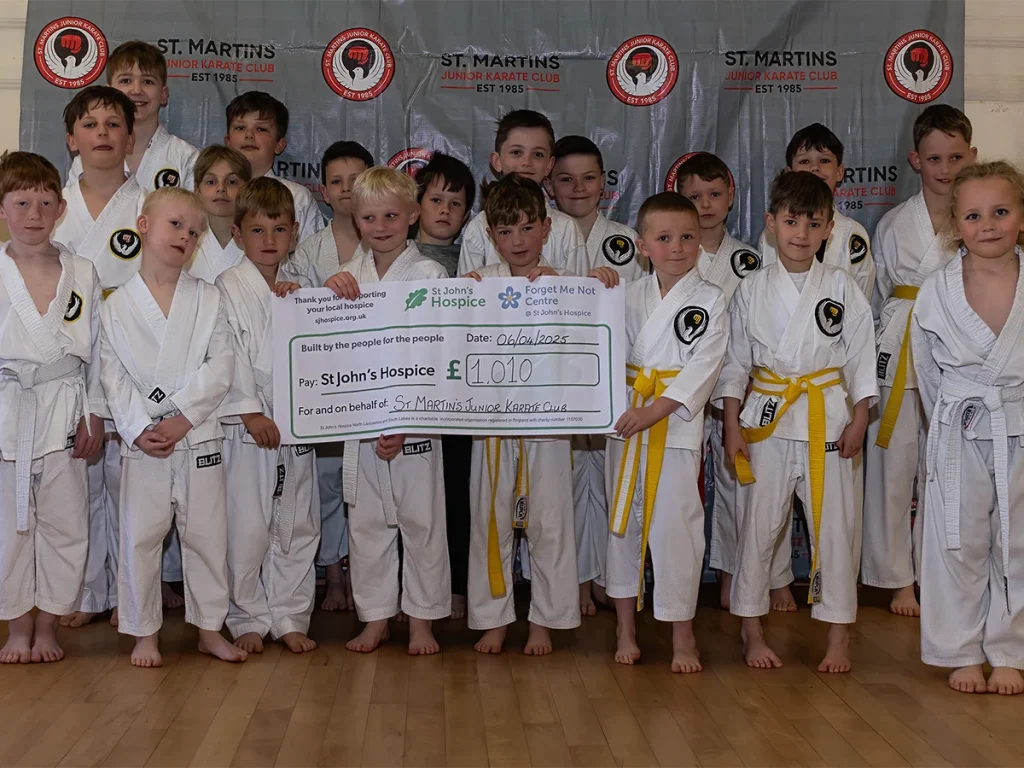 St Martins Junior Karate Club members presenting a £1,010 fundraising cheque for St John's Hospice