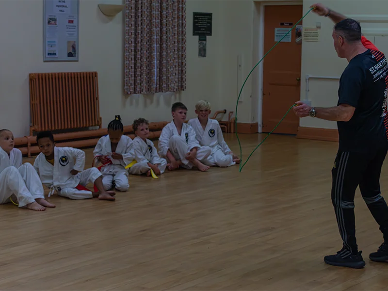 Karate instructor guiding junior students during class