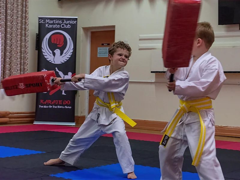 Junior karate students practising a partner pad drill